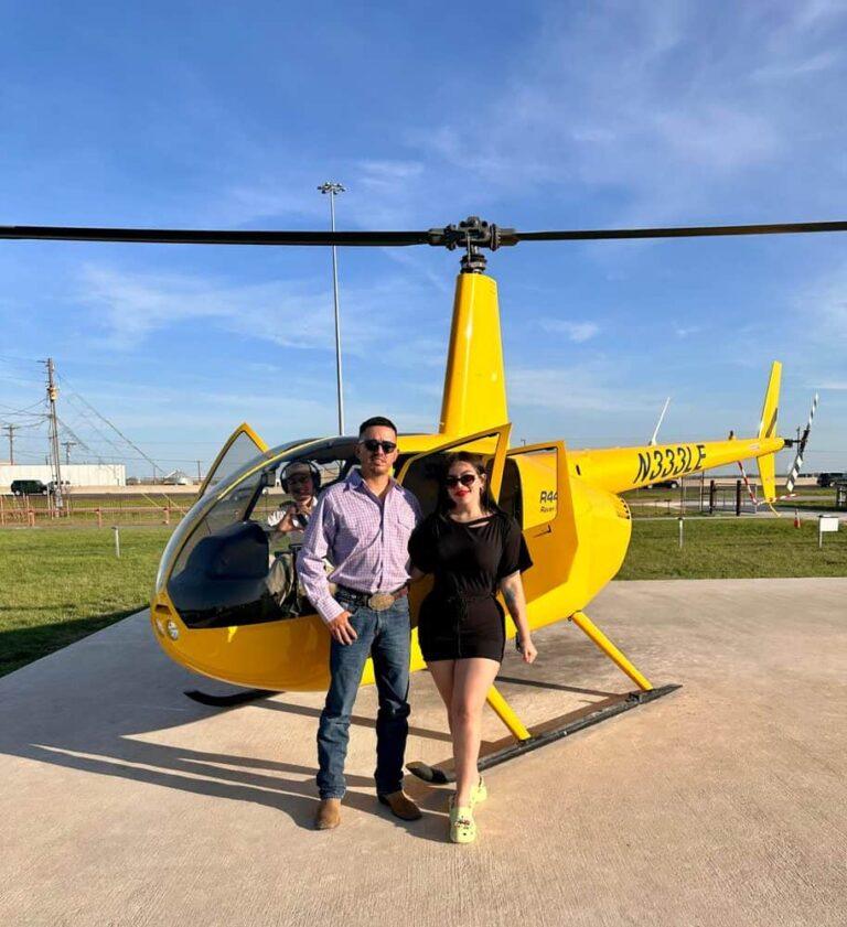 Couple beside yellow helicopter before Houston luxury tour and romantic flight experience