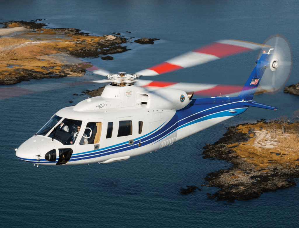 Sikorsky S-76D helicopter flying over water for luxury business charter travel