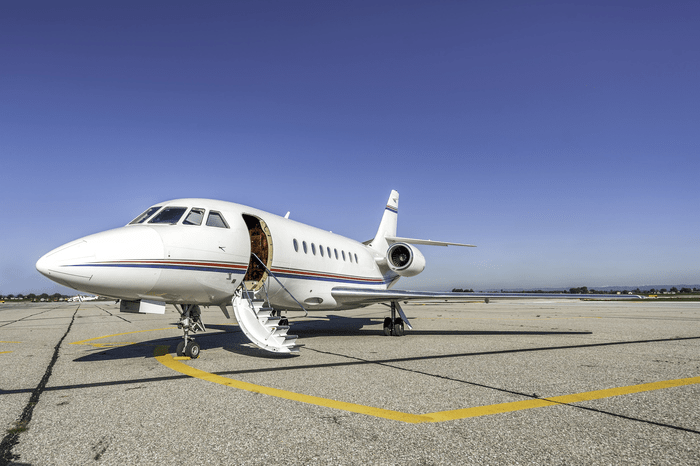 Luxury private jet on the runway highlighting the difference between buying and chartering private aircraft