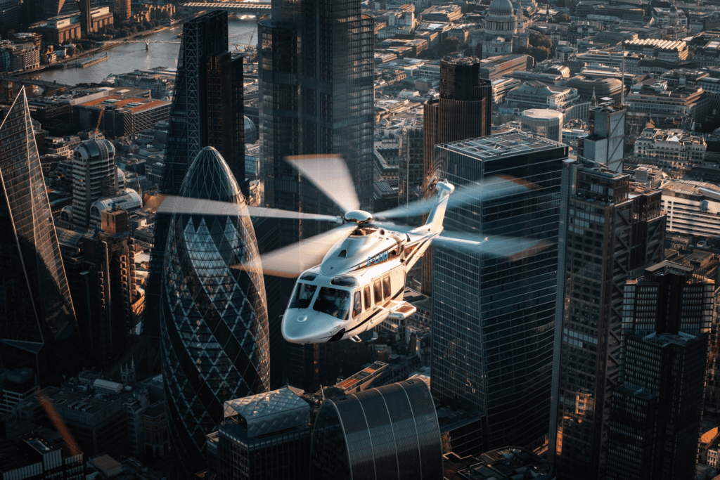 Helicopter flying between city skyscrapers illustrating pricing and value of aerial tours