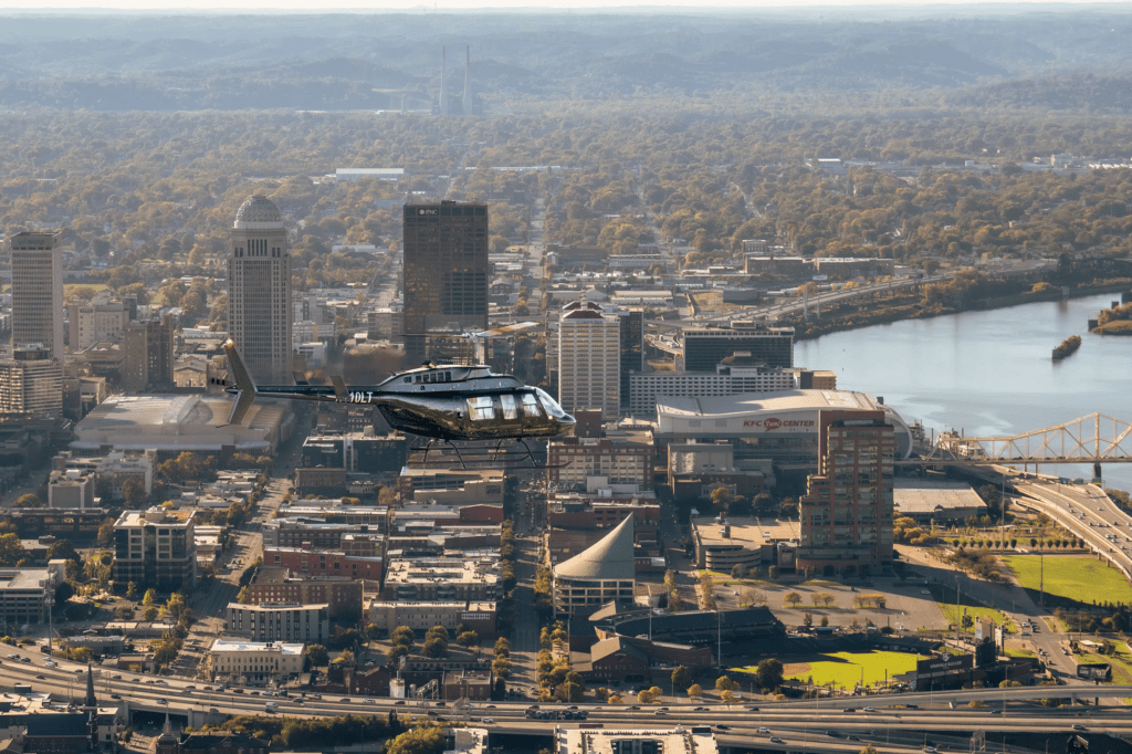 Helicopter flying over city and river emphasizing safety standards pilot training and passenger comfort