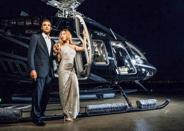 Elegant couple beside luxury helicopter highlighting exclusive Austin TX helicopter ride experience