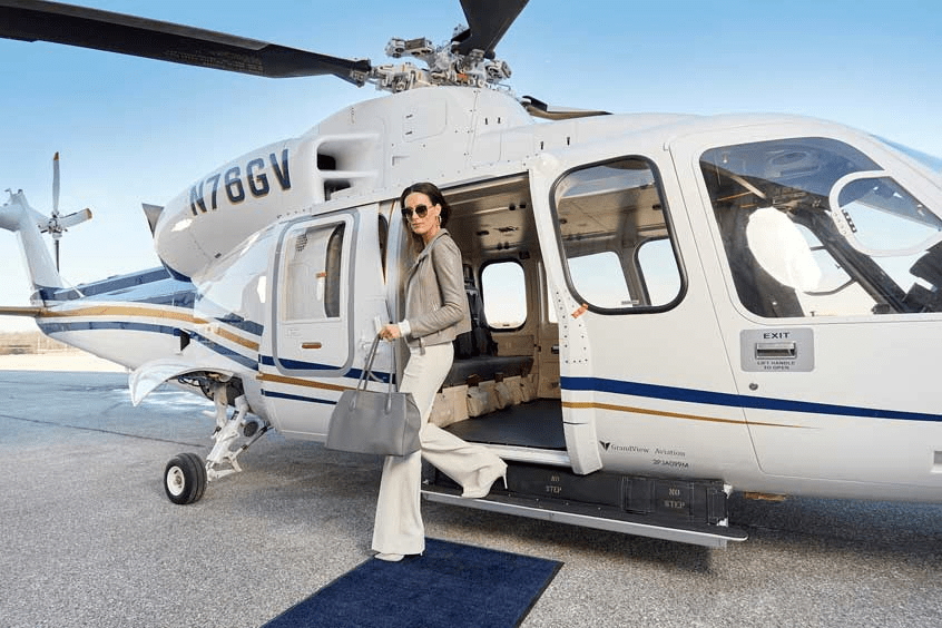 Happy passengers wearing headsets during helicopter flight with scenic coastal view